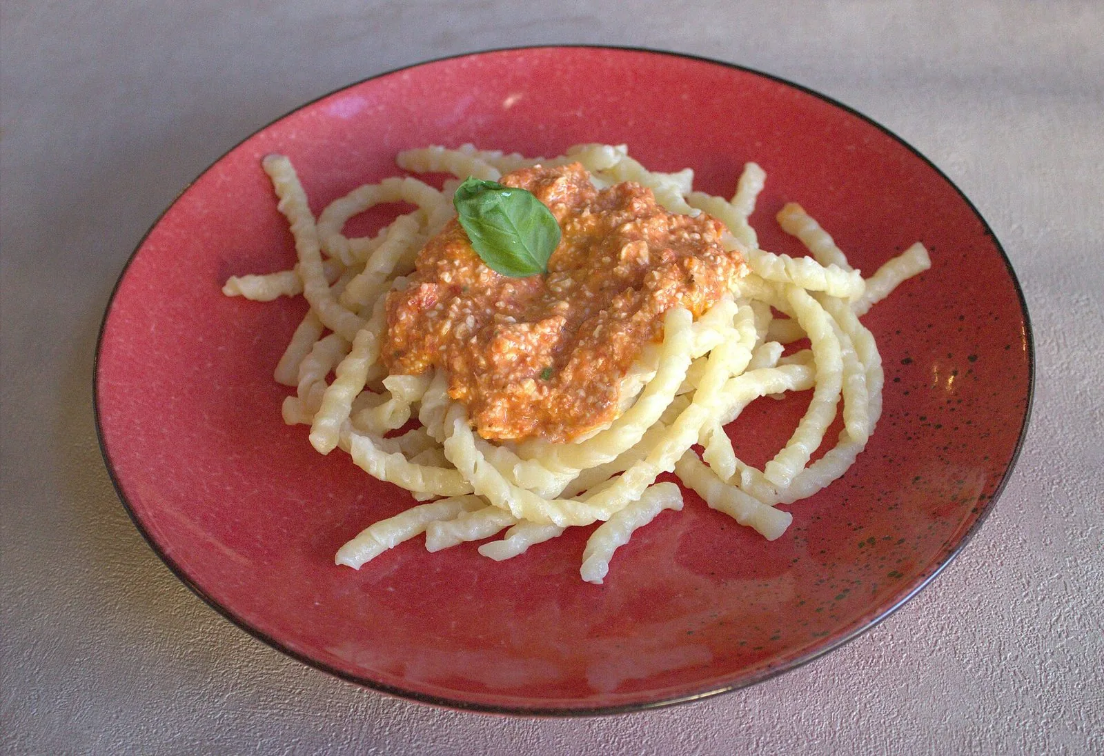 Un piatto di busiate condite con il pesto alla trapanese
